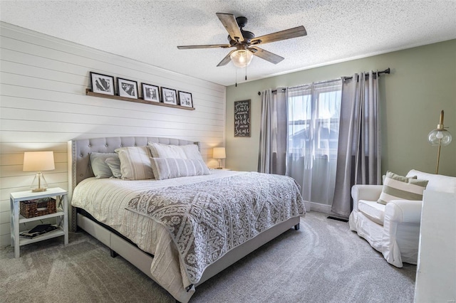 carpeted bedroom featuring ceiling fan and a textured ceiling