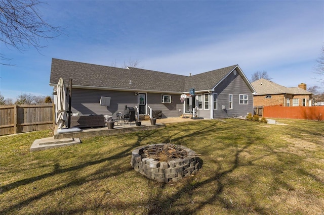 back of property featuring a yard, a fire pit, and a patio