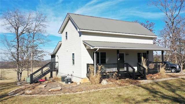 view of front facade featuring central AC, a front lawn, and covered porch