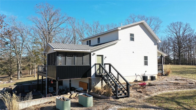 rear view of house featuring a sunroom