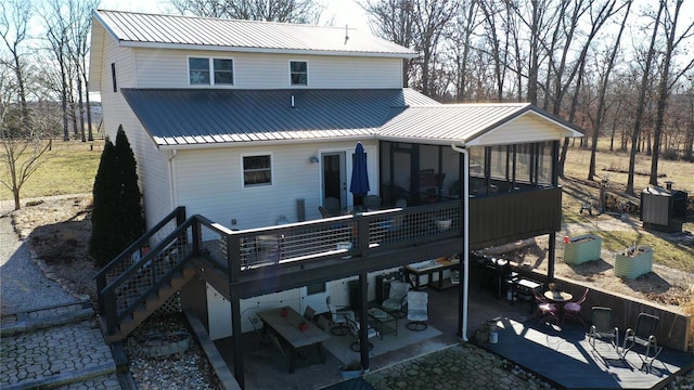 back of property with a sunroom, a patio, and a deck