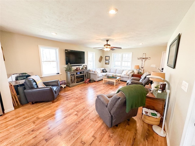 living room with a wealth of natural light, a textured ceiling, and light hardwood / wood-style floors