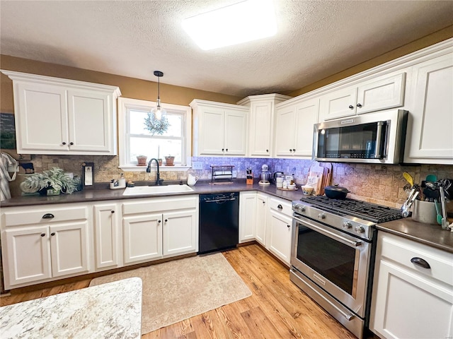 kitchen with stainless steel appliances, decorative light fixtures, sink, and white cabinets