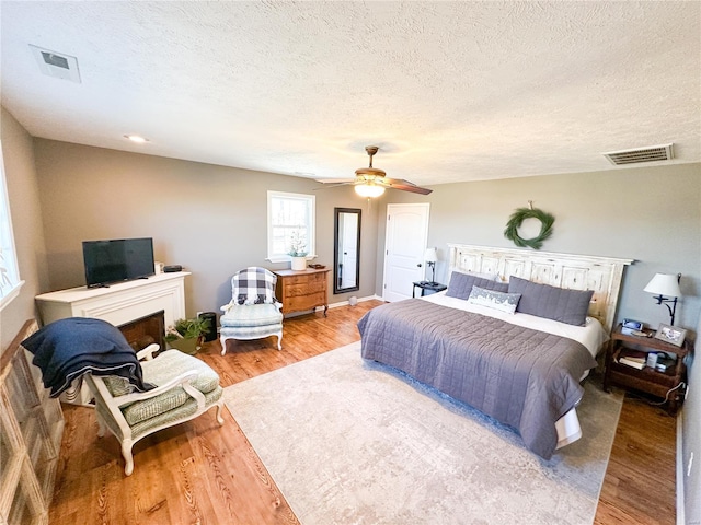 bedroom featuring wood-type flooring, a textured ceiling, and ceiling fan