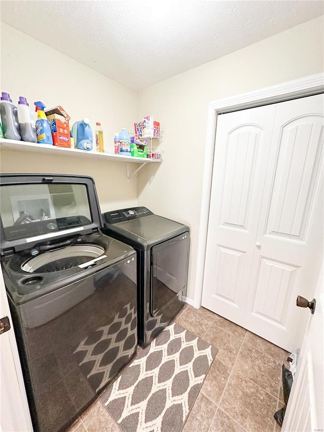 washroom with washer and clothes dryer and a textured ceiling