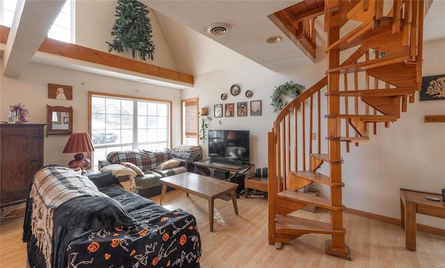 living room featuring light hardwood / wood-style flooring and high vaulted ceiling