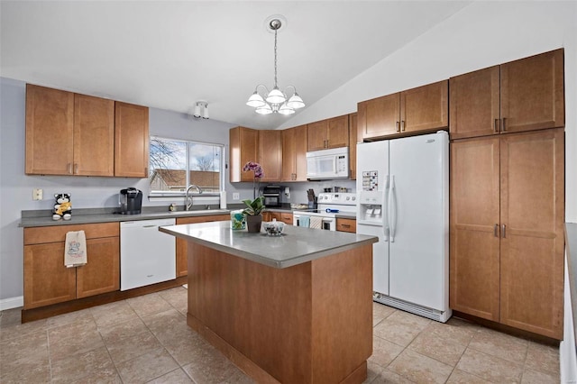 kitchen with pendant lighting, sink, white appliances, a kitchen island, and vaulted ceiling