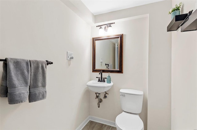 bathroom with hardwood / wood-style floors and toilet