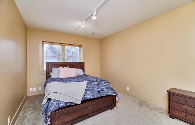 carpeted bedroom featuring rail lighting