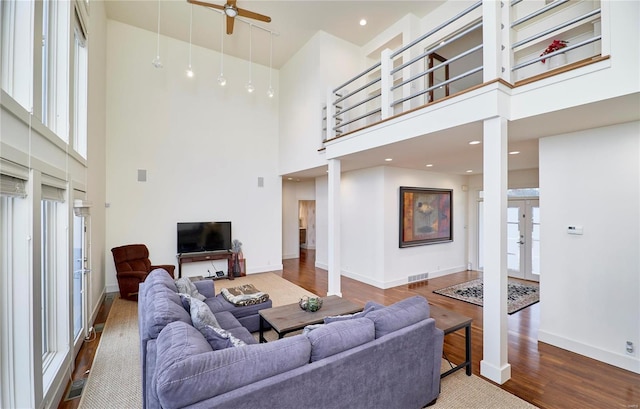 living room featuring a high ceiling, hardwood / wood-style floors, and french doors