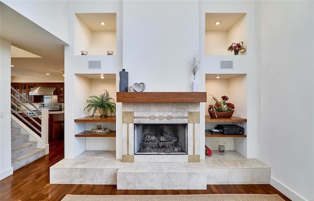 living room featuring a tiled fireplace and hardwood / wood-style flooring