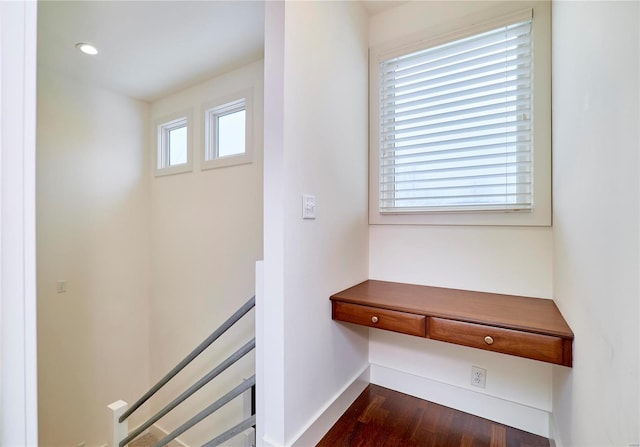 stairs featuring hardwood / wood-style flooring and built in desk