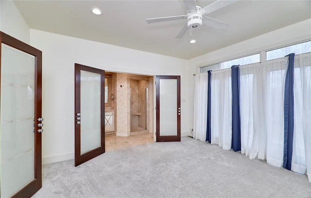 unfurnished bedroom with french doors, light colored carpet, and ensuite bath