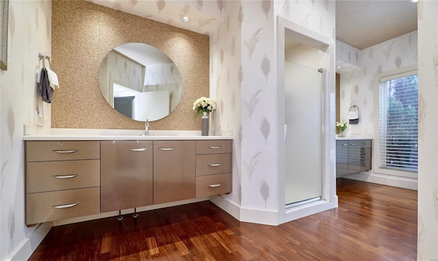 bathroom with wood-type flooring, a shower with door, and vanity