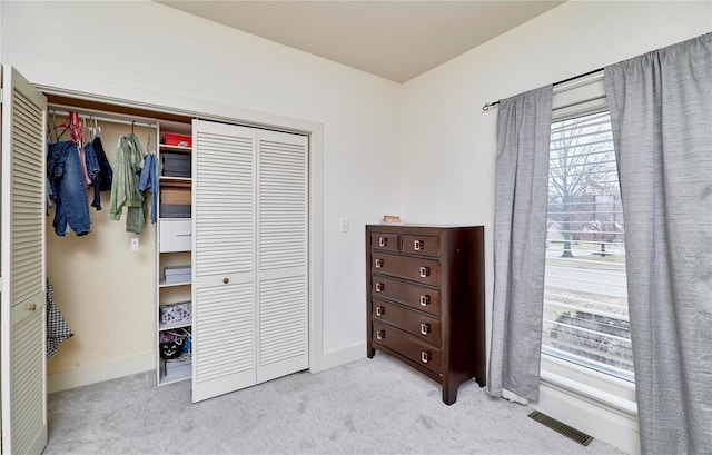 bedroom featuring light colored carpet and a closet