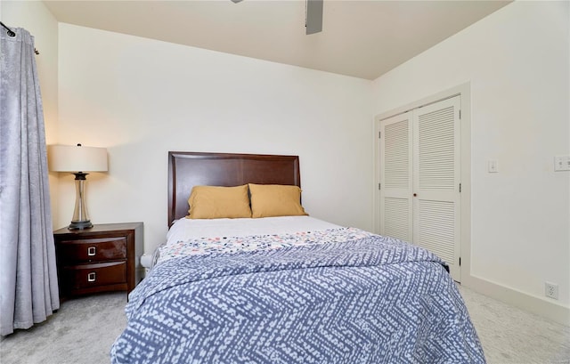 bedroom featuring light colored carpet, a closet, and ceiling fan