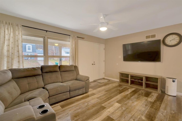 living room with ceiling fan and light hardwood / wood-style flooring