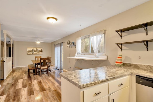 kitchen featuring light stone counters, light hardwood / wood-style flooring, stainless steel dishwasher, ceiling fan, and white cabinets