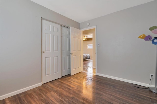 unfurnished bedroom with dark hardwood / wood-style floors and a closet