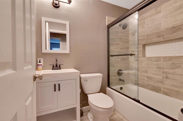 full bathroom featuring enclosed tub / shower combo, vanity, and toilet