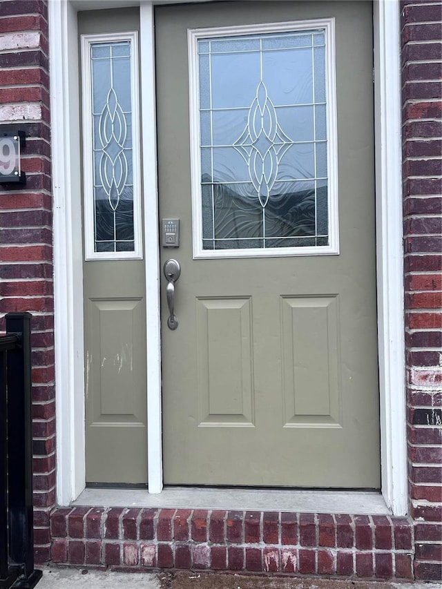 doorway to property featuring brick siding