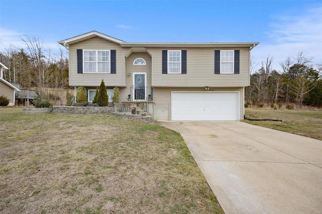 raised ranch featuring a garage and a front lawn