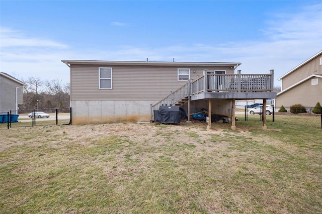 back of house featuring a wooden deck and a lawn