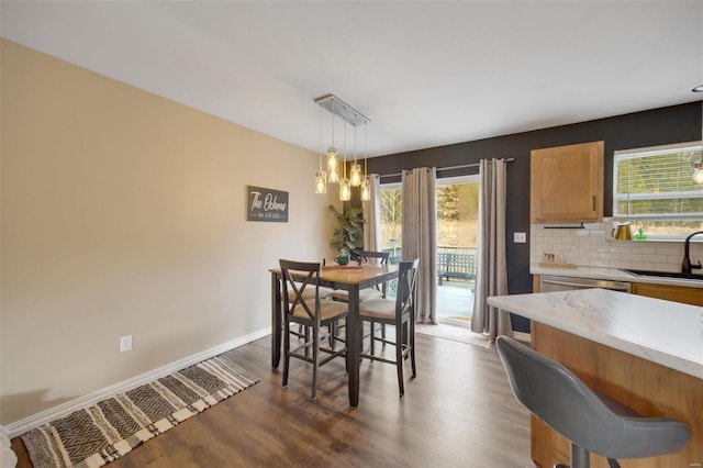 dining space featuring an inviting chandelier, sink, and hardwood / wood-style floors