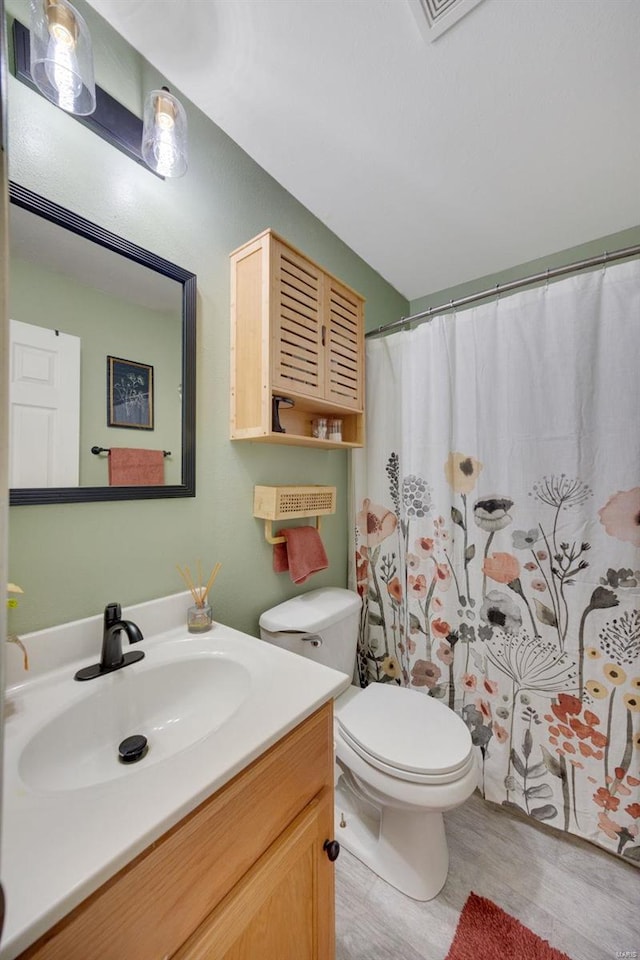 bathroom with vanity, toilet, and walk in shower