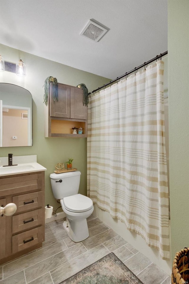 full bathroom with vanity, shower / tub combo with curtain, and toilet