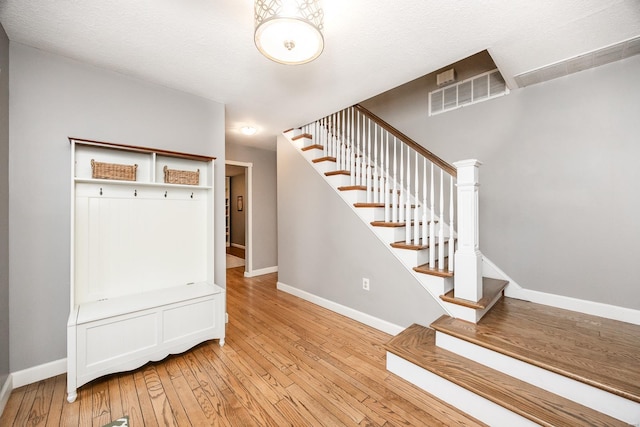 mudroom featuring light hardwood / wood-style flooring and a textured ceiling