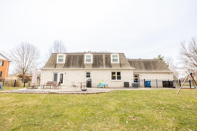 back of house featuring central AC unit, a playground, a patio area, and a lawn