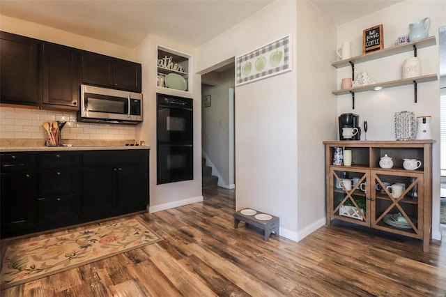 kitchen featuring hardwood / wood-style flooring, black double oven, and backsplash