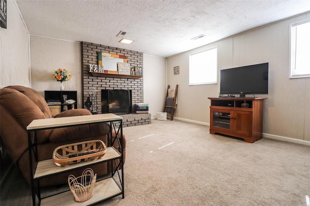 carpeted living room featuring a fireplace, a textured ceiling, and a wealth of natural light