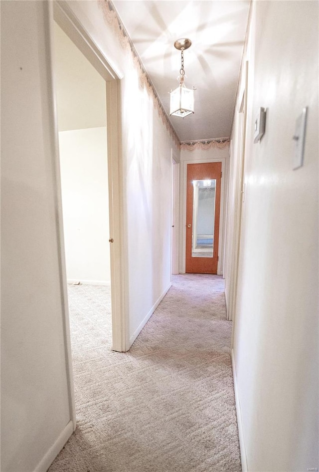 hallway featuring light colored carpet