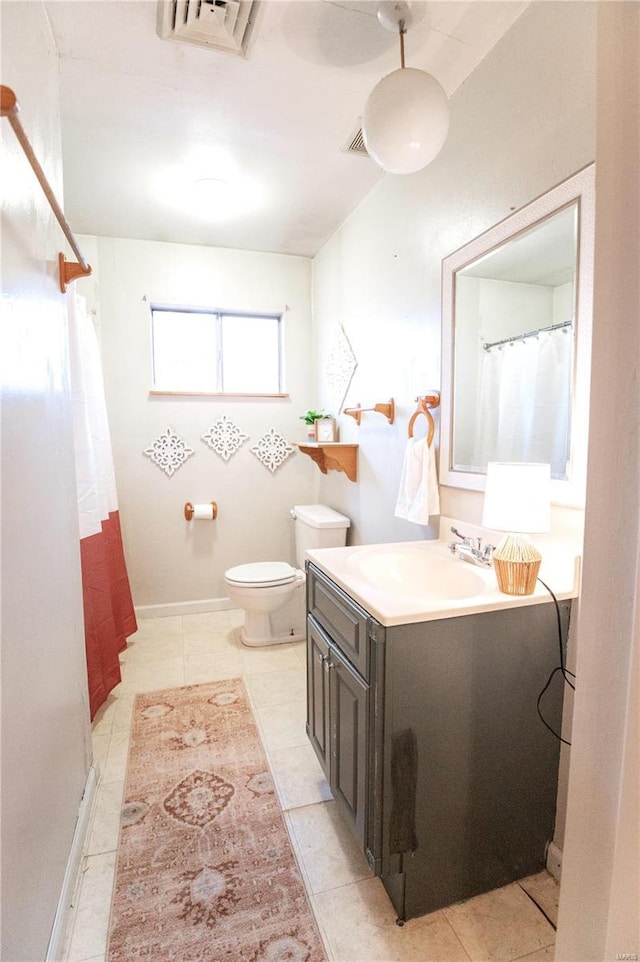 bathroom featuring vanity, tile patterned flooring, and toilet