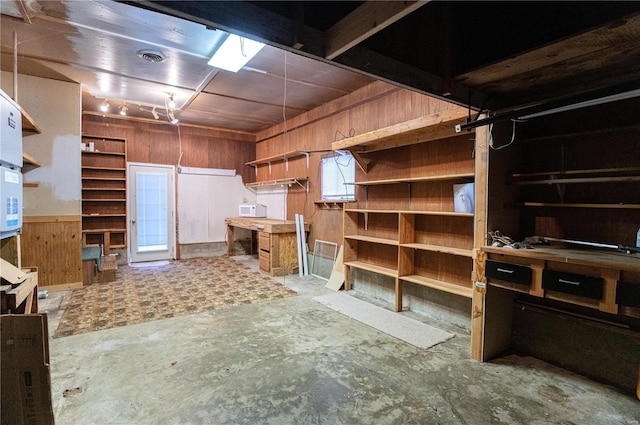 basement with wooden walls and a workshop area