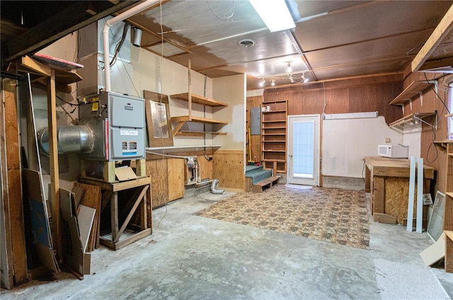 basement featuring electric panel and wood walls