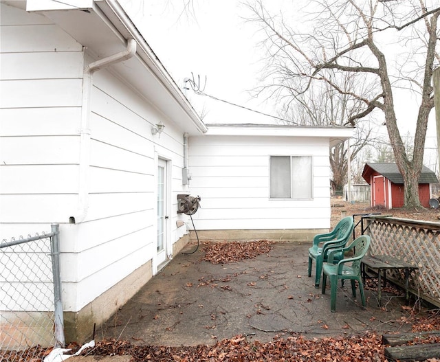 view of side of property featuring a patio and a storage shed