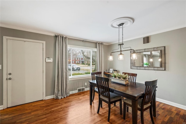 dining space featuring crown molding and hardwood / wood-style floors