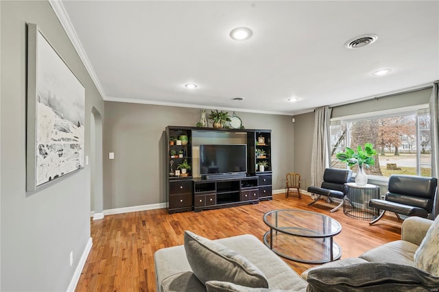 living room featuring crown molding and light hardwood / wood-style floors