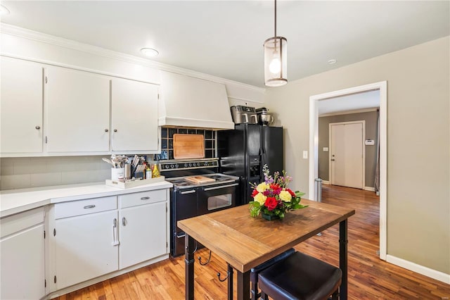 kitchen featuring white cabinetry, decorative light fixtures, decorative backsplash, and black appliances