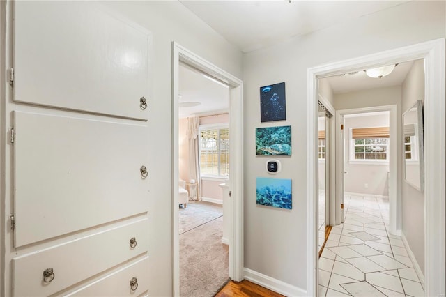 hall with a wealth of natural light and light tile patterned flooring