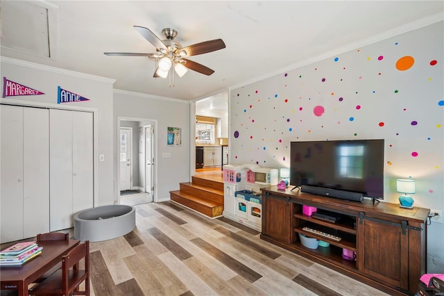 living room with crown molding, light hardwood / wood-style floors, and ceiling fan