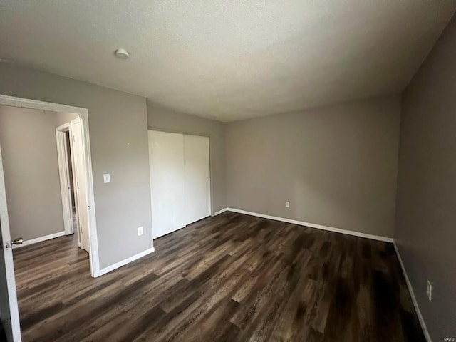 unfurnished bedroom featuring dark wood-type flooring and a closet