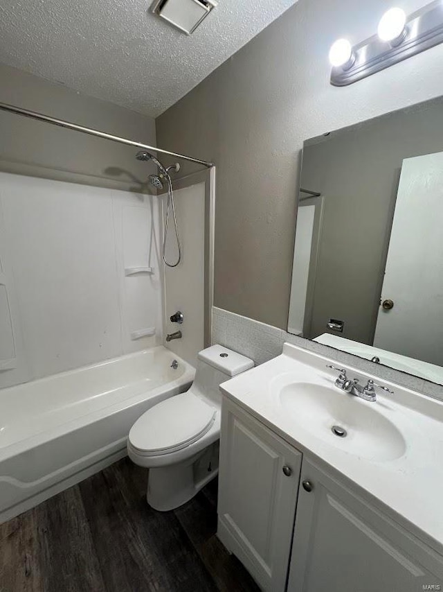 full bathroom with toilet, bathtub / shower combination, a textured ceiling, vanity, and hardwood / wood-style floors