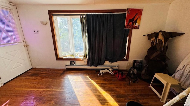 interior space featuring dark hardwood / wood-style flooring and a baseboard heating unit