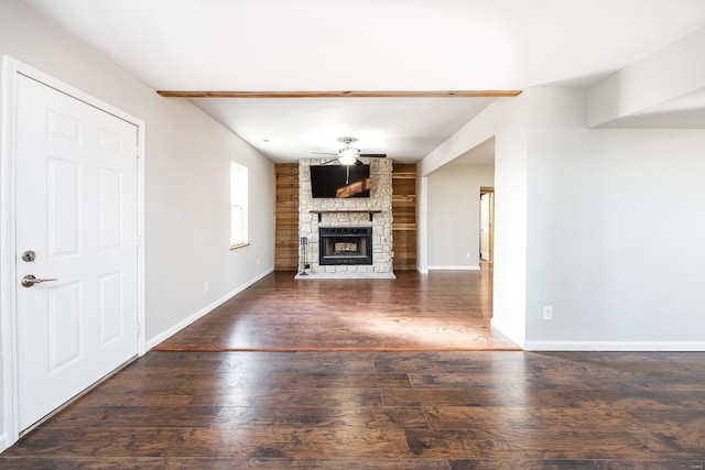 unfurnished living room featuring a fireplace, dark hardwood / wood-style floors, and ceiling fan