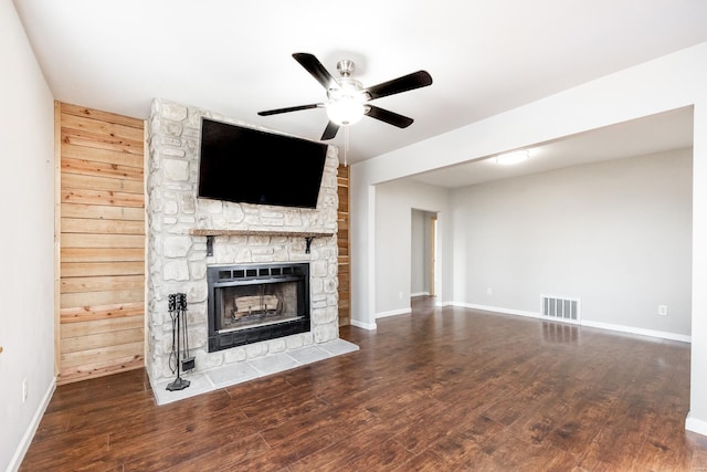 unfurnished living room with dark wood-type flooring, ceiling fan, and a fireplace