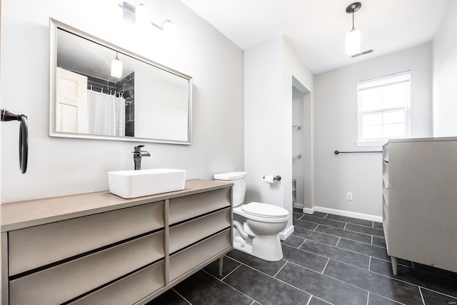 bathroom featuring tile patterned flooring, vanity, curtained shower, and toilet